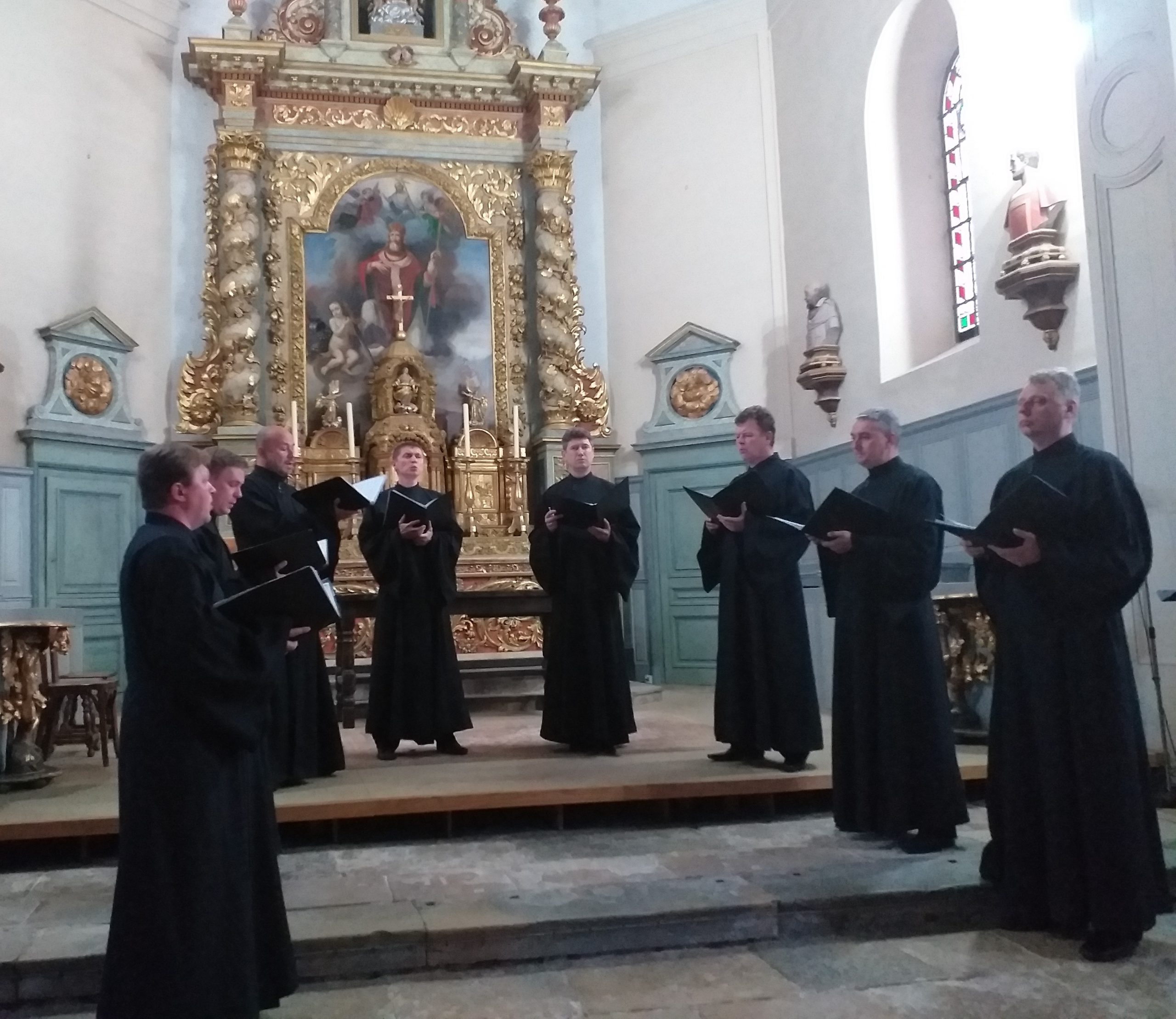 Les hommes en chasubles noires interprètent des chants de la liturgie orthodoxe.